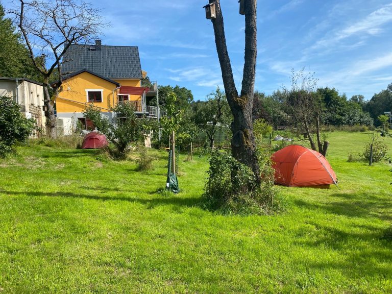 Die Zeltwiese. 2 rote Zelte auf unterschiedlichen Wiesen-Terrassen