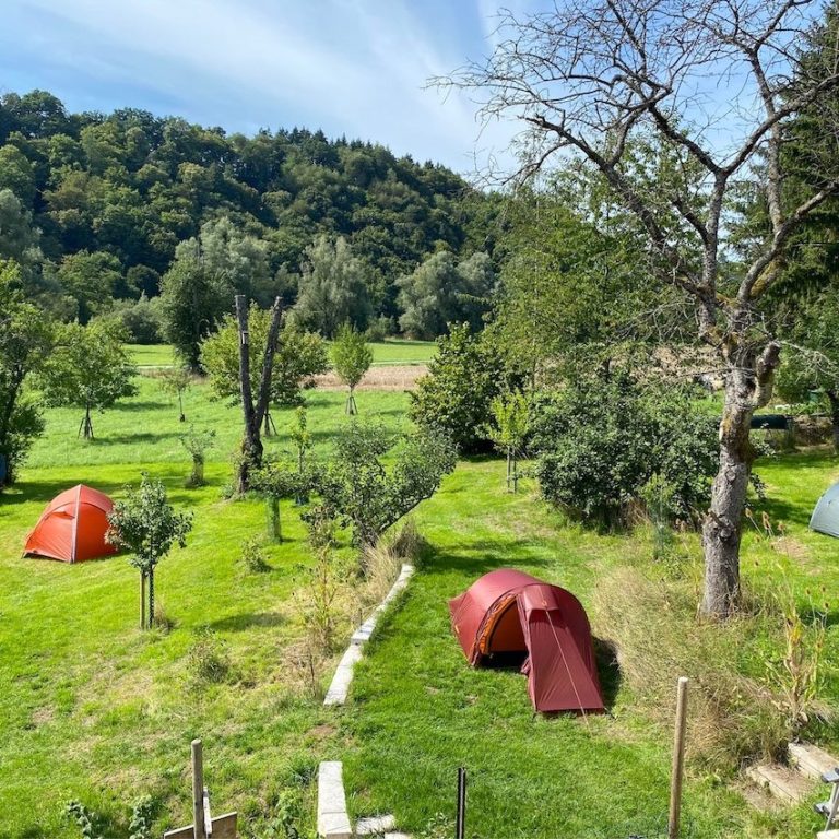 Das Wiesengrundstück mit 2 aufgebauten Zelten. Im Hintergrund der Hang von Löhnberg  